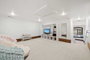 Carpeted living room with baseboards, visible vents, and recessed lighting
