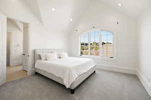 apartment Bedroom featuring baseboards, recessed lighting, light colored carpet, and high vaulted ceiling