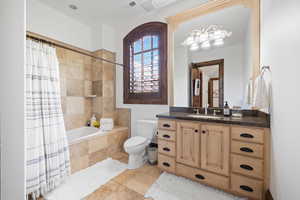 Full bath featuring toilet, tiled shower / bath, vanity, and visible vents