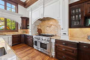 Kitchen with double oven range, a healthy amount of sunlight, and tasteful backsplash