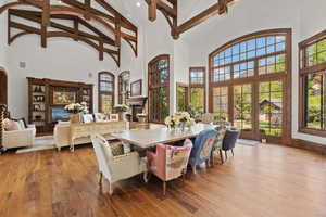 Dining area featuring beamed ceiling, high vaulted ceiling, and a lit fireplace