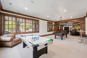 Playroom with light colored carpet, ornamental molding, pool table, visible vents, and arched walkways