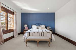 Bedroom featuring baseboards, recessed lighting, an accent wall, and carpet floors