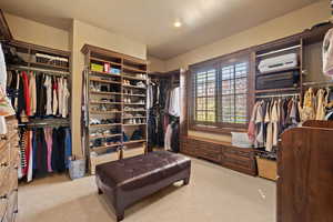 Spacious closet with light colored carpet and a wall mounted AC