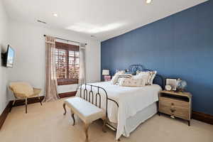 Bedroom featuring light colored carpet, visible vents, and baseboards
