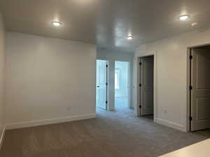 Carpeted spare room with a textured ceiling, baseboards, a smoke detector, and recessed lighting