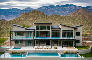 Rear view of house with a balcony, a mountain view, outdoor lounge area, a patio, and a pool with connected hot tub