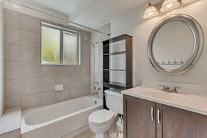 Bathroom with toilet, vanity, washtub / shower combination, and tile patterned flooring
