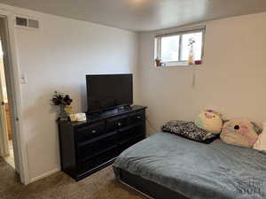 Carpeted bedroom with baseboards and a textured wall