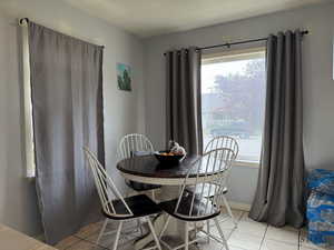 Dining space featuring light tile patterned floors and healthy amount of natural light