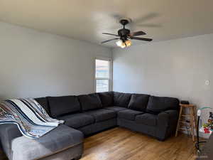 Living room featuring wood finished floors and a ceiling fan