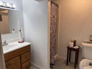 Full bath featuring toilet, vanity, tile patterned floors, and a shower with shower curtain