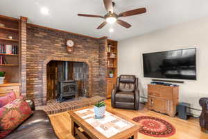 Family room featuring a gas stove, a ceiling fan, white oak hardwood flooring