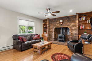 Family area featuring a gas stove, ceiling fan, and white oak hardwood flooring