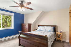 Carpeted bedroom featuring baseboards, ceiling fan, and a textured ceiling