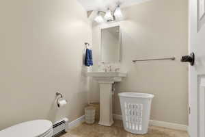 Bathroom featuring toilet, tile patterned flooring, and baseboards