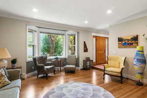 Living area with recessed lighting, white oak hardwood finished floors, baseboards, and crown molding.