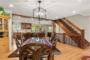 Dining space featuring a chandelier, white oak hardwood flooring, recessed lighting, a stunning custom-built walnut staircase, and baseboards