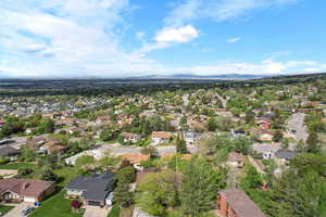 Aerial view of property and surrounding area with nearby suburban area and a mountainous background