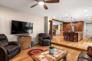 Family room featuring white oak hardwood flooring, a ceiling fan, recessed lighting
