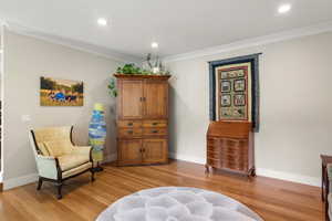 Living area with white oak hardwood flooring, recessed lighting, baseboards, and ornamental molding