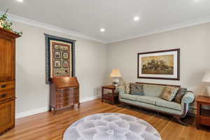Living room featuring white oak hardwood flooring, crown molding, baseboards, and recessed lighting