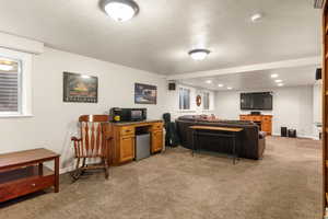 Family room with light carpet, a textured ceiling, baseboards, and recessed lighting