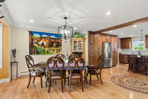 Dining area with white oak hardwood flooring, a chandelier,, recessed lighting, and ornamental molding