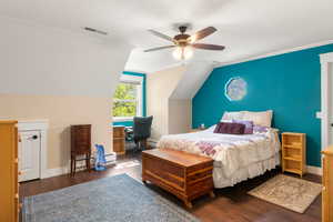 Bedroom featuring synthetic walnut floors, vaulted ceiling, ceiling fan, and ornamental molding