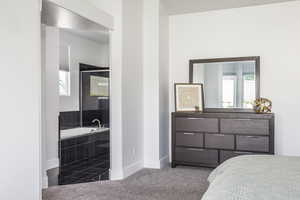 Carpeted bedroom with multiple windows and baseboards