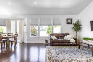 Living area with dark wood-style flooring, baseboards, and recessed lighting