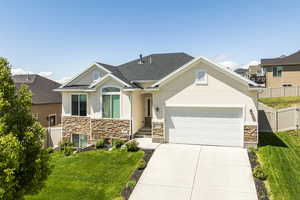 Craftsman-style home featuring stone siding, stucco siding, a garage, concrete driveway, and central AC