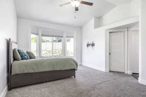 Bedroom with carpet floors, vaulted ceiling, baseboards, and ceiling fan