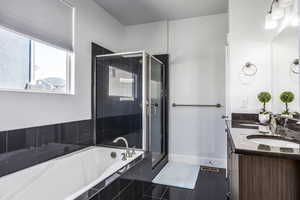 Full bath featuring tile patterned flooring, a shower stall, a garden tub, and double vanity