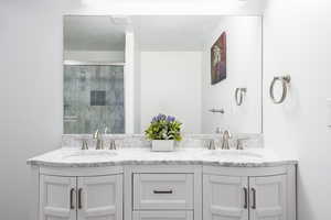 Full bathroom with tiled shower and double vanity