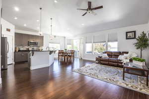 Living room with a ceiling fan, dark wood-style flooring, recessed lighting, and baseboards