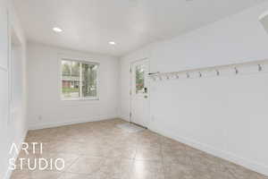 Interior space featuring light tile patterned floors, baseboards, wainscoting, and recessed lighting
