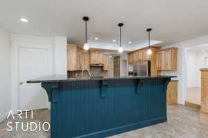 Kitchen with a breakfast bar, stainless steel fridge, and baseboards