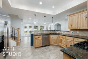 Kitchen with recessed lighting, stainless steel appliances, light brown cabinetry, and a sink