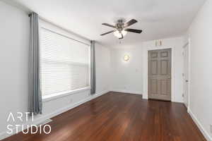Unfurnished room featuring dark wood-type flooring, baseboards, visible vents, and ceiling fan