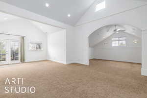 Additional living space with carpet flooring, ceiling fan, and arched walkways