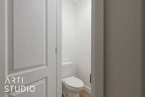 Bathroom with tile patterned floors, toilet, and baseboards