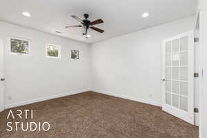 Carpeted spare room with a ceiling fan, visible vents, and recessed lighting