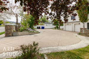 Exterior space with stone siding, a mountain view, driveway, and fence