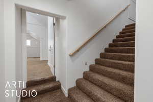 Stairway with baseboards, carpet floors, and arched walkways