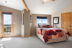 Bedroom featuring vaulted ceiling, access to deck, carpet floors, baseboards, and ceiling fan