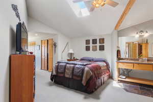 Bedroom featuring a skylight, light carpet, baseboards, and high vaulted ceiling