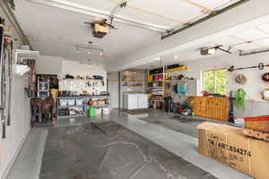 Garage featuring separate washer and dryer, a garage door opener, and a workshop area