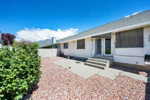View of front of property featuring fence, roof with shingles, a patio, and entry steps
