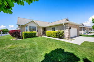 Ranch-style home featuring a garage, a front lawn, concrete driveway, and roof with shingles